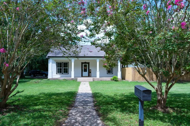 a front view of a house with yard and green space