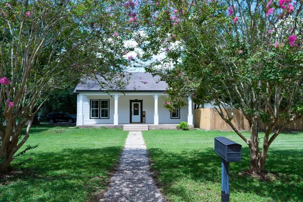 a front view of a house with yard and green space