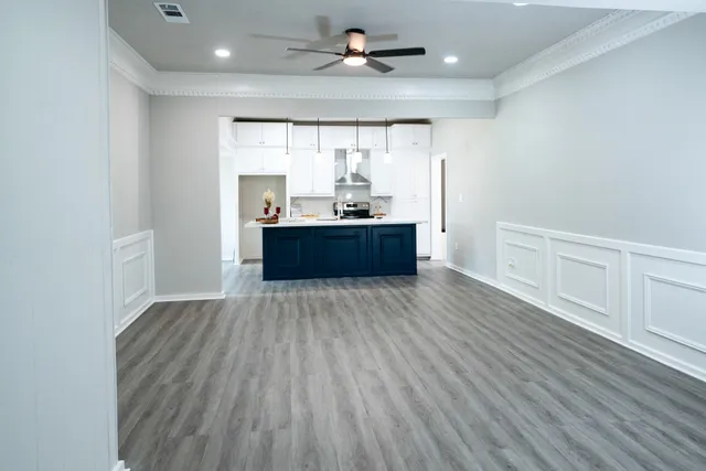 a large room with wooden floor and chandelier