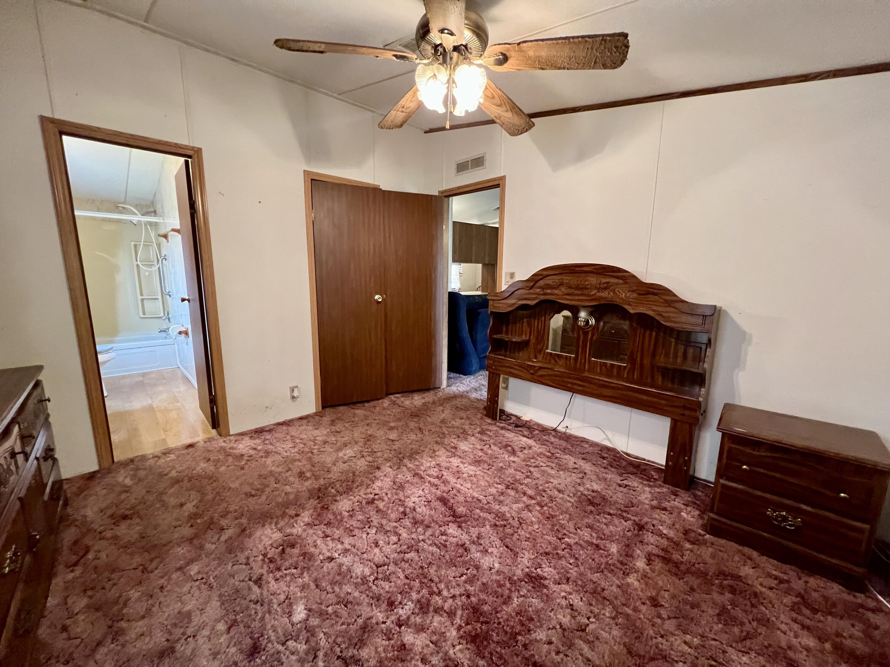 1303 Jordan Loop Okeechobee, FL 34974 - Photo 30 of 33 a bedroom with a bed and a chandelier