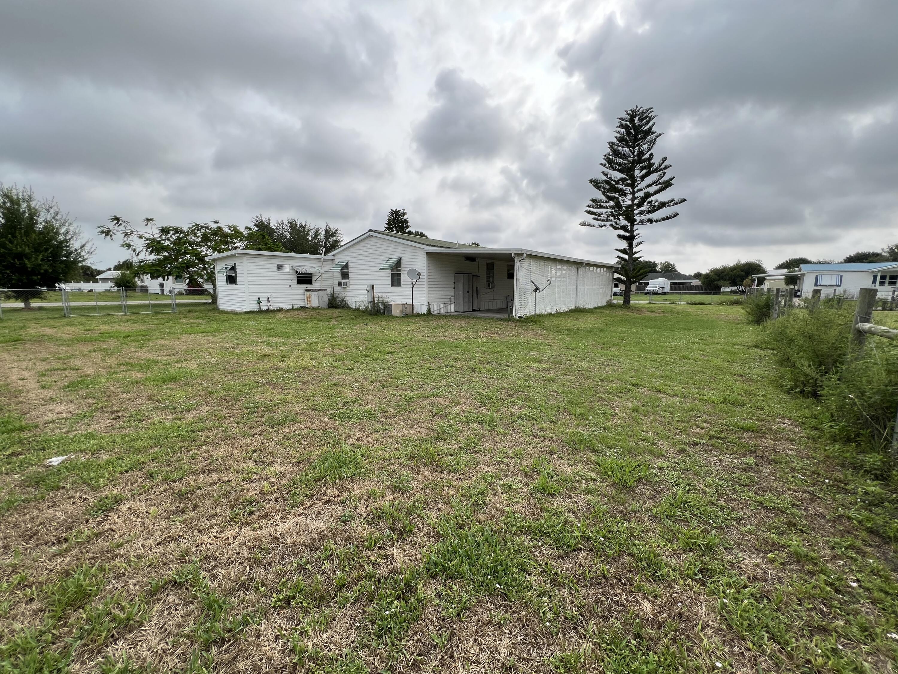 1303 Jordan Loop Okeechobee, FL 34974 - Photo 33 of 33 a front view of house with yard and trees