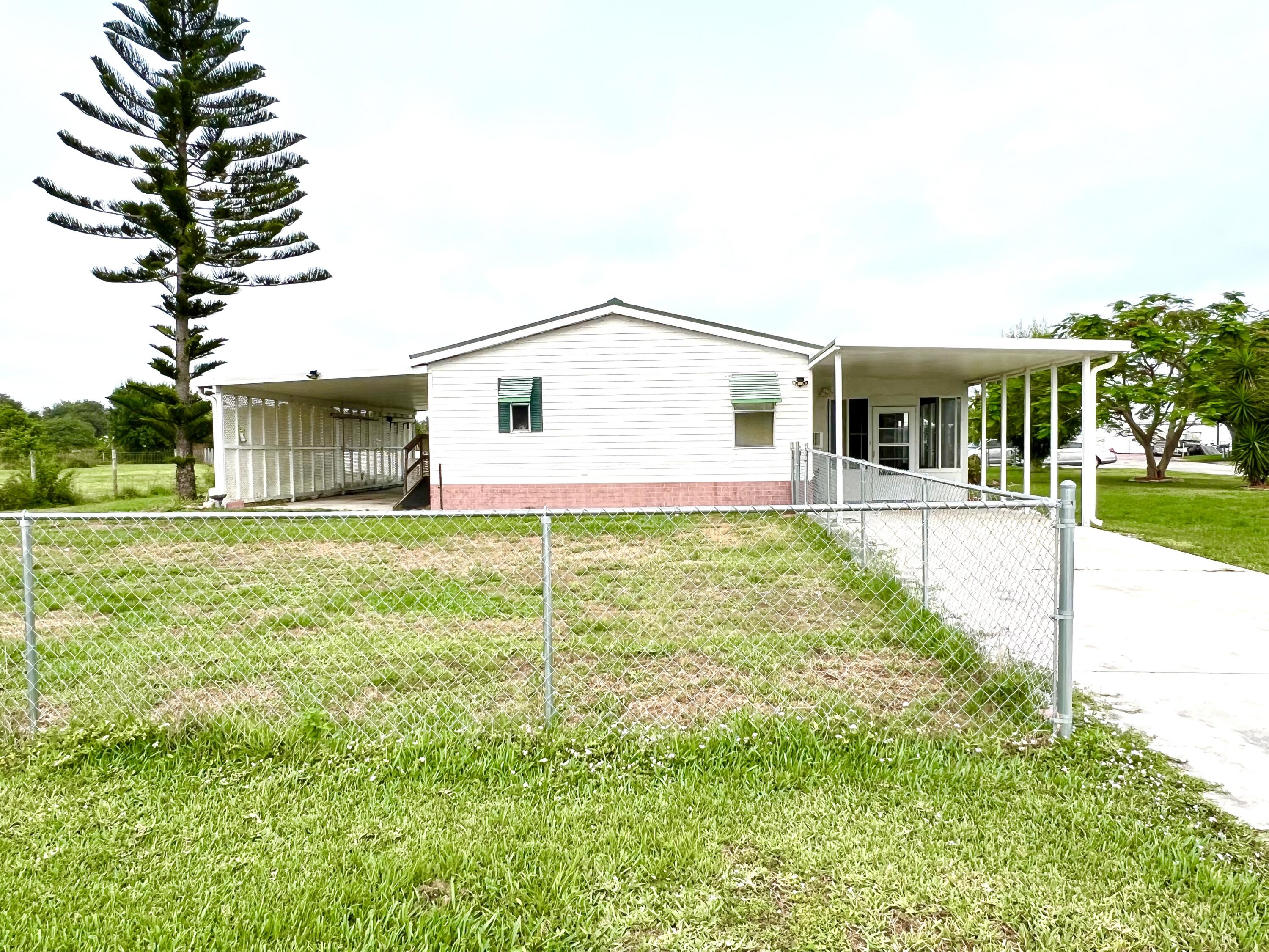1303 Jordan Loop Okeechobee, FL 34974 - Photo 4 of 33 a front view of a house with garden