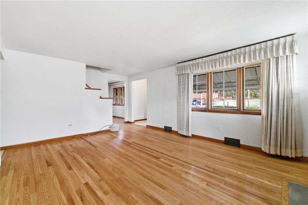5626 5th Street Pittsburgh, PA 15236 - Photo 4 of 38 a view of an empty room with wooden floor and a window