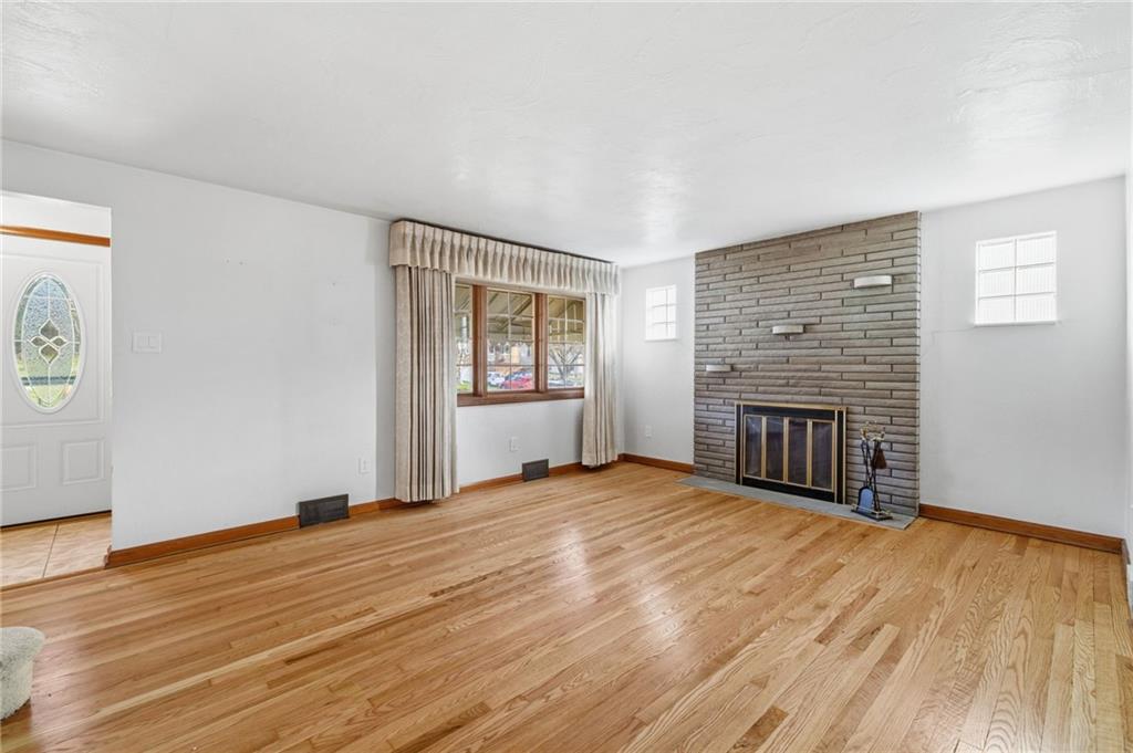 5626 5th Street Pittsburgh, PA 15236 - Photo 5 of 38 an empty room with wooden floor fireplace and windows