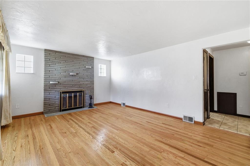 5626 5th Street Pittsburgh, PA 15236 - Photo 6 of 38 an empty room with wooden floor and fireplace
