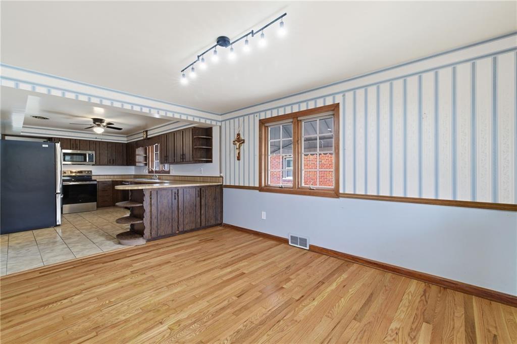 5626 5th Street Pittsburgh, PA 15236 - Photo 9 of 38 a room with stainless steel appliances wooden floor and chandelier
