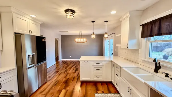 a kitchen with stainless steel appliances a refrigerator sink and wooden floor