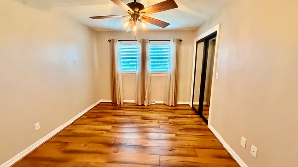 a view of a room with a ceiling fan and window