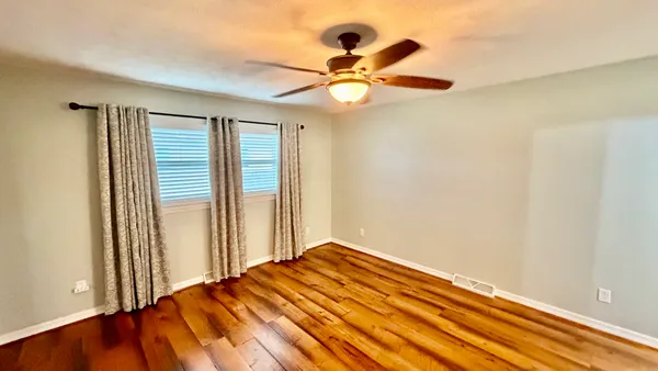a view of a livingroom with a ceiling fan and window