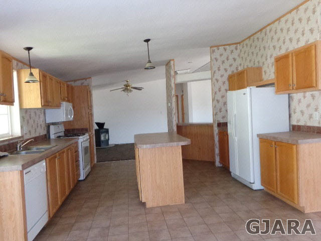 3551 E Road Palisade, CO 81526 - Photo 5 of 8 a kitchen with granite countertop a refrigerator and a stove