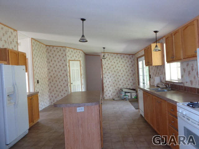 3551 E Road Palisade, CO 81526 - Photo 6 of 8 a kitchen with granite countertop a sink stove and refrigerator