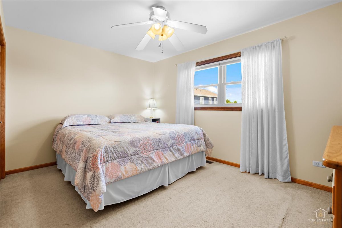 8124 Nottingham Road Tinley Park, IL 60477 - Photo 14 of 33 a bedroom with a bed and a chandelier