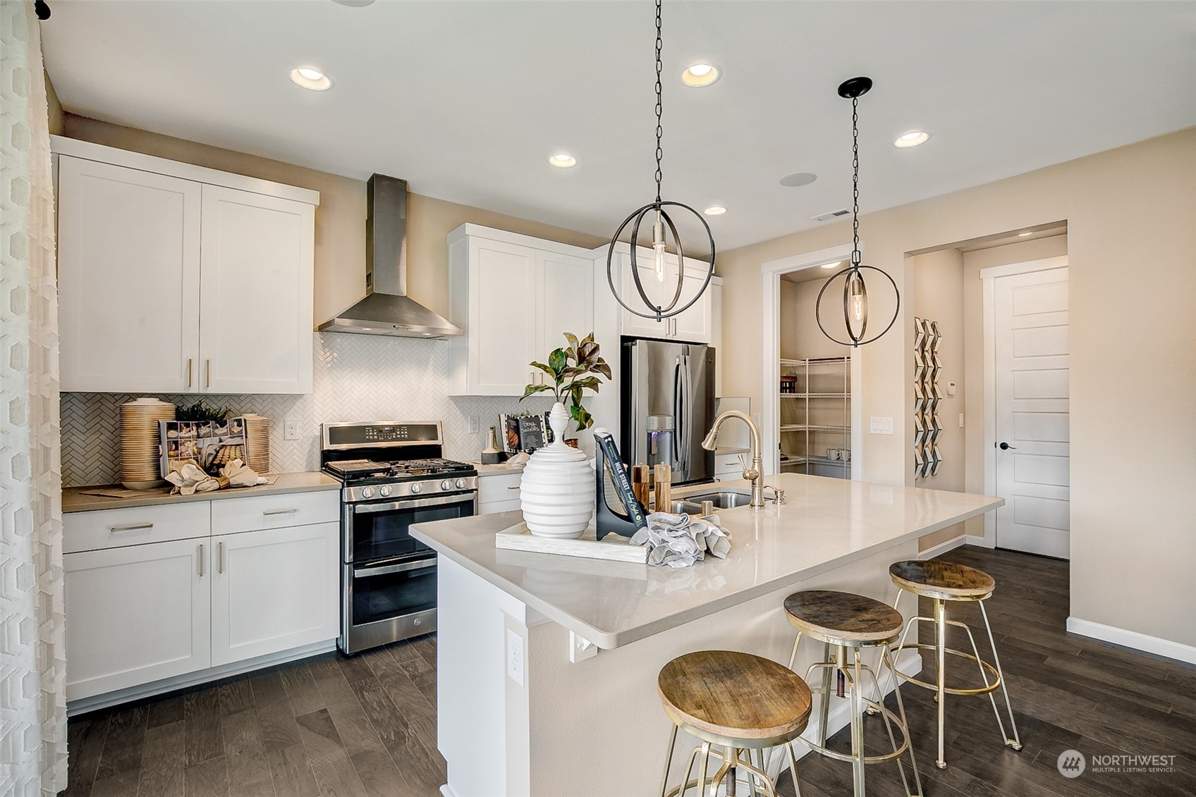 10304 Balto Road Northwest, Unit 37 Silverdale, WA 98383 - Photo 10 of 21 a kitchen with stainless steel appliances a stove a sink a dining table and chairs with wooden floor