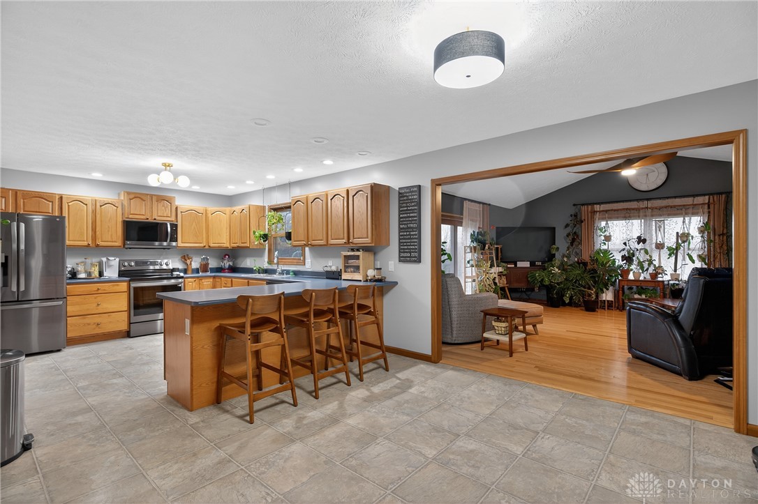 5264 Frazier-Guy Road Sidney, OH 45365 - Photo 12 of 51 This spacious kitchen offers ample cabinetry and counter space, seamlessly connecting to the adjacent living area.