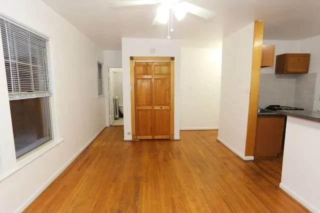 a view of a hallway with wooden floor and closet