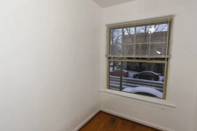 a view of a small space with wooden floor and a window