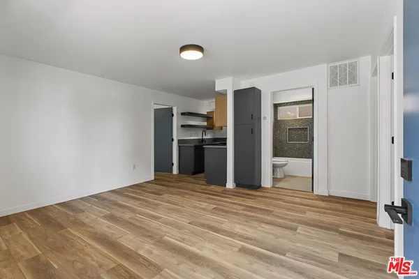 a view of a kitchen with wooden floor and a refrigerator