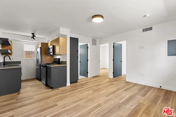 a kitchen with stainless steel appliances kitchen island granite countertop a refrigerator stove top oven and sink