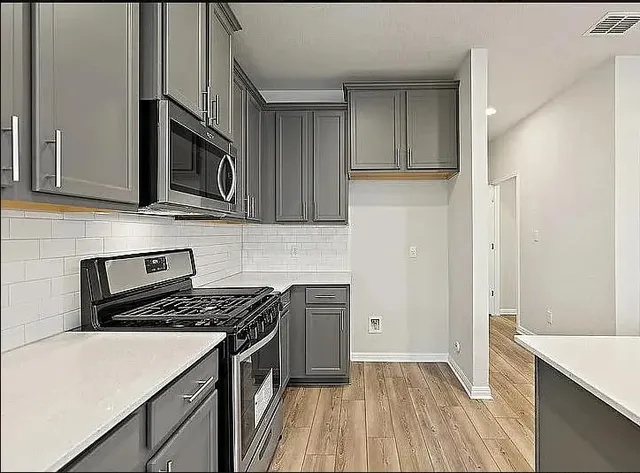 a kitchen with a stove microwave and sink
