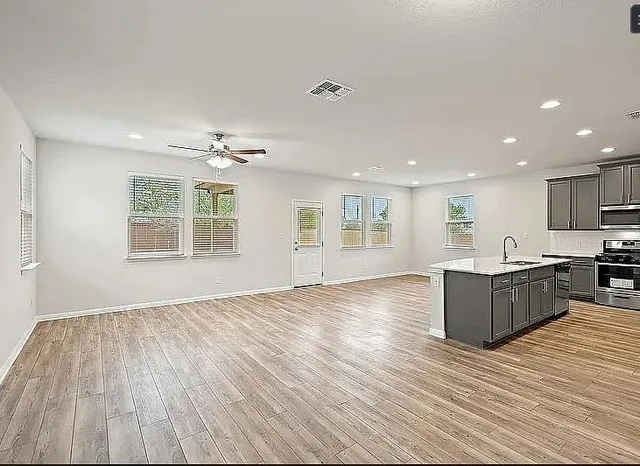 a living room with hard wood floors and a kitchen