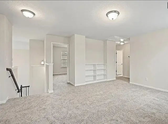 an empty room with a cabinet and mirrors