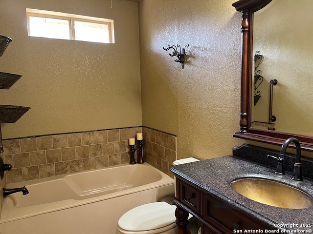 1216 Mocking Bird Circle Pleasanton, TX 78064 - Photo 15 of 31 a bathroom with a granite countertop toilet sink and bathtub