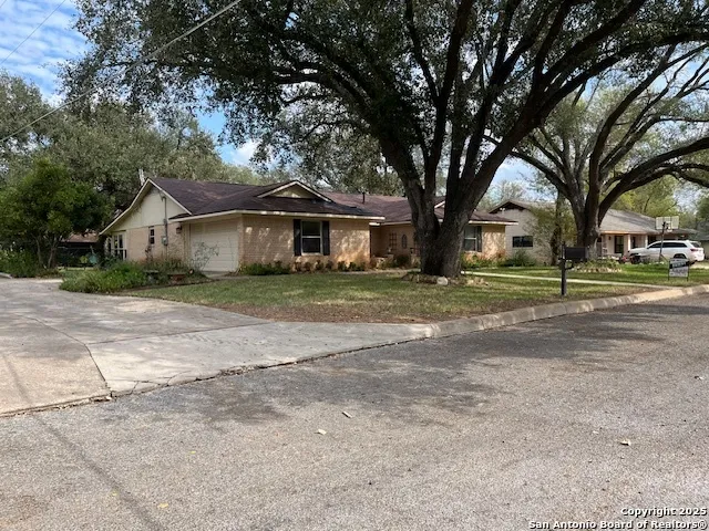 a front view of a house with a garden and trees
