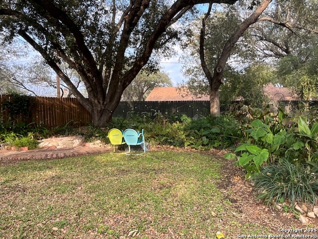 1216 Mocking Bird Circle Pleasanton, TX 78064 - Photo 24 of 31 a backyard of a house with table and chairs under an umbrella
