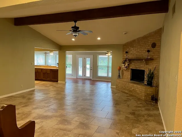 a view of an empty room with a fireplace and a window