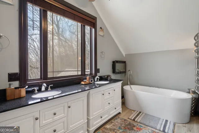 a bathroom with a granite countertop sink mirror and a bathtub