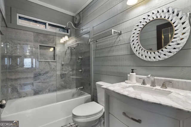 a bathroom with a granite countertop sink mirror vanity and toilet