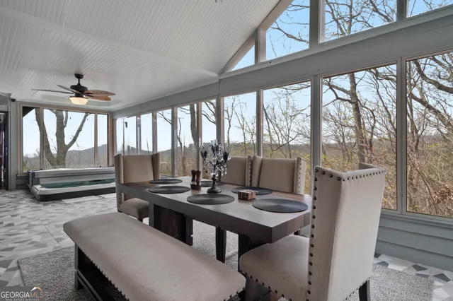 a view of a dining room with furniture large windows and wooden floor