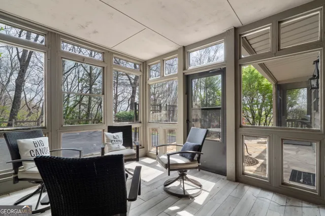 a living room with furniture a floor to ceiling window and wooden floor