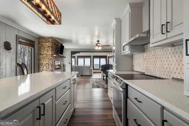 a kitchen with a sink dishwasher stove and wooden cabinets