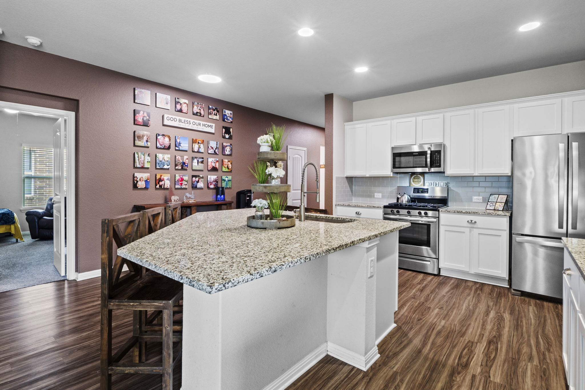 2417 Bridges Ranch Road Georgetown, TX 78628 - Photo 22 of 36 Kitchen featuring stainless steel appliances, white cabinets, light stone countertops, and dark wood-style floors