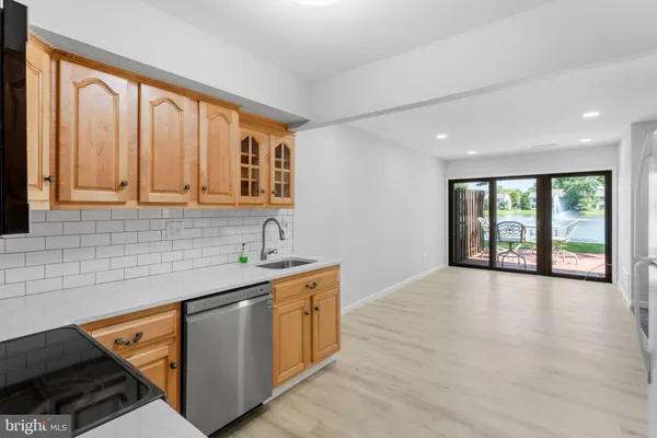 a kitchen with stainless steel appliances granite countertop a sink a stove and a wooden cabinets