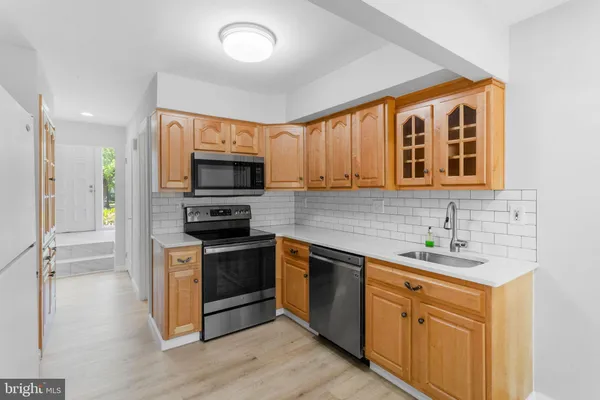 a kitchen with sink a microwave and cabinets