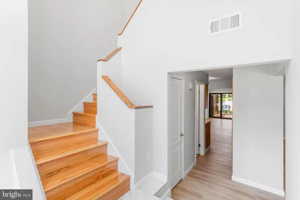 a view of a hallway with wooden floor and staircase