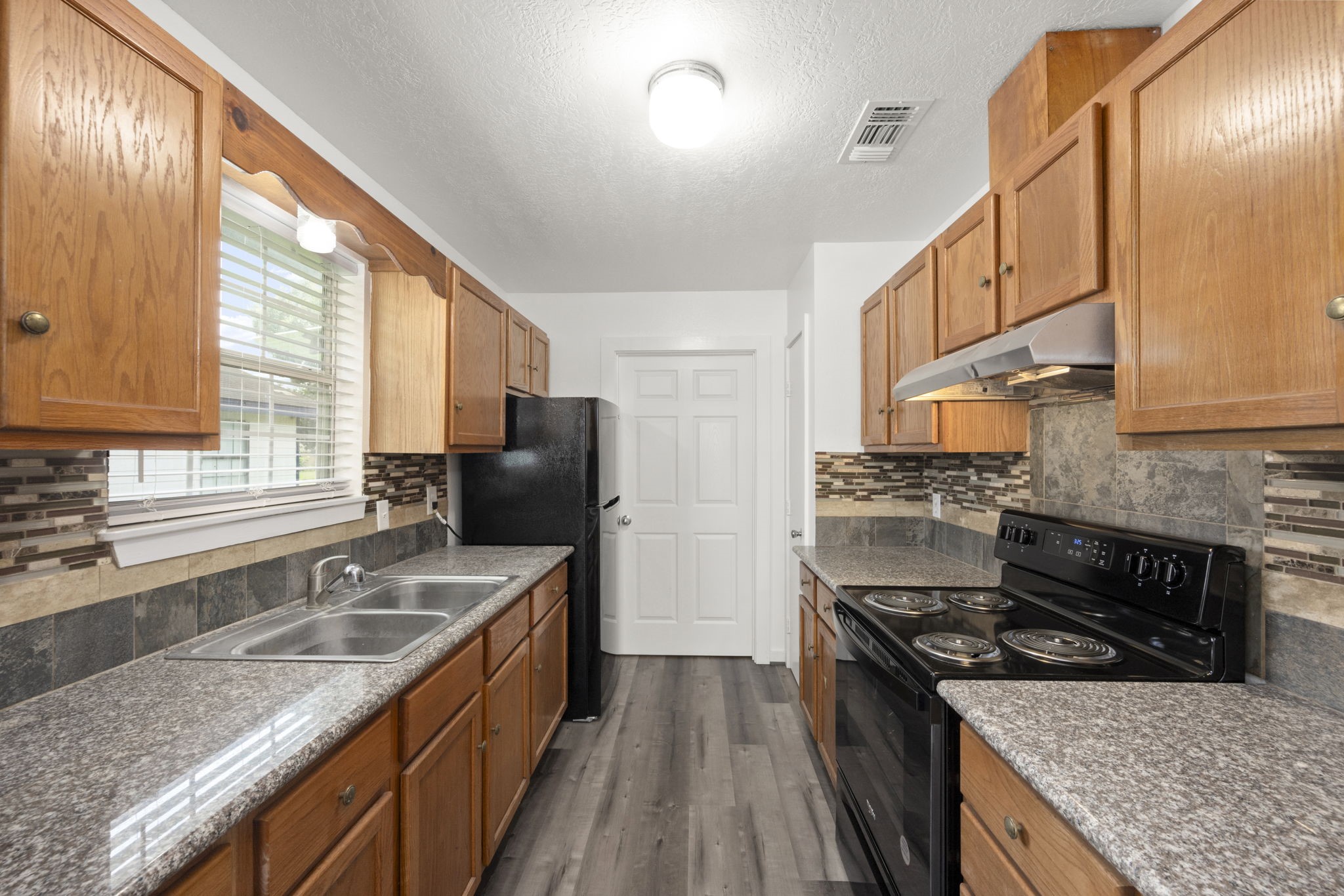 1935 1st Street Hempstead, TX 77445 - Photo 18 of 29 a kitchen with stainless steel appliances granite countertop a sink stove and refrigerator