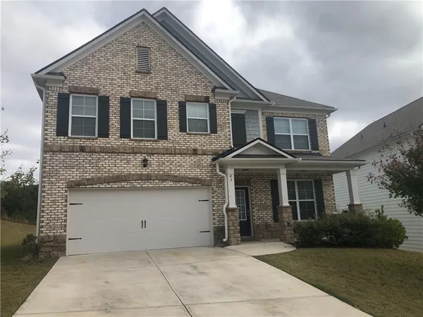 a front view of a house with a garden and garage