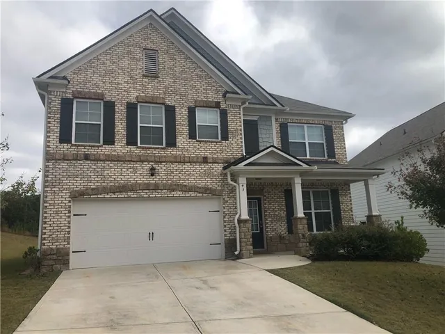 a front view of a house with a garden and garage