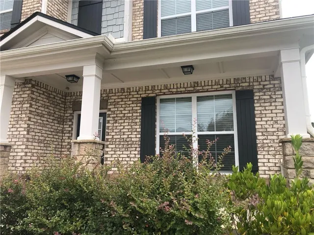 a front view of a house with large windows and a flower pot