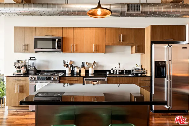 a kitchen with stainless steel appliances granite countertop a sink and a stove