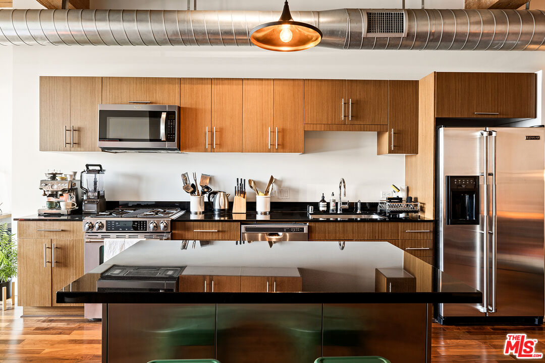 530 South Hewitt Street, Unit 425 Los Angeles, CA 90013 - Photo 7 of 22 a kitchen with stainless steel appliances granite countertop a sink and a stove