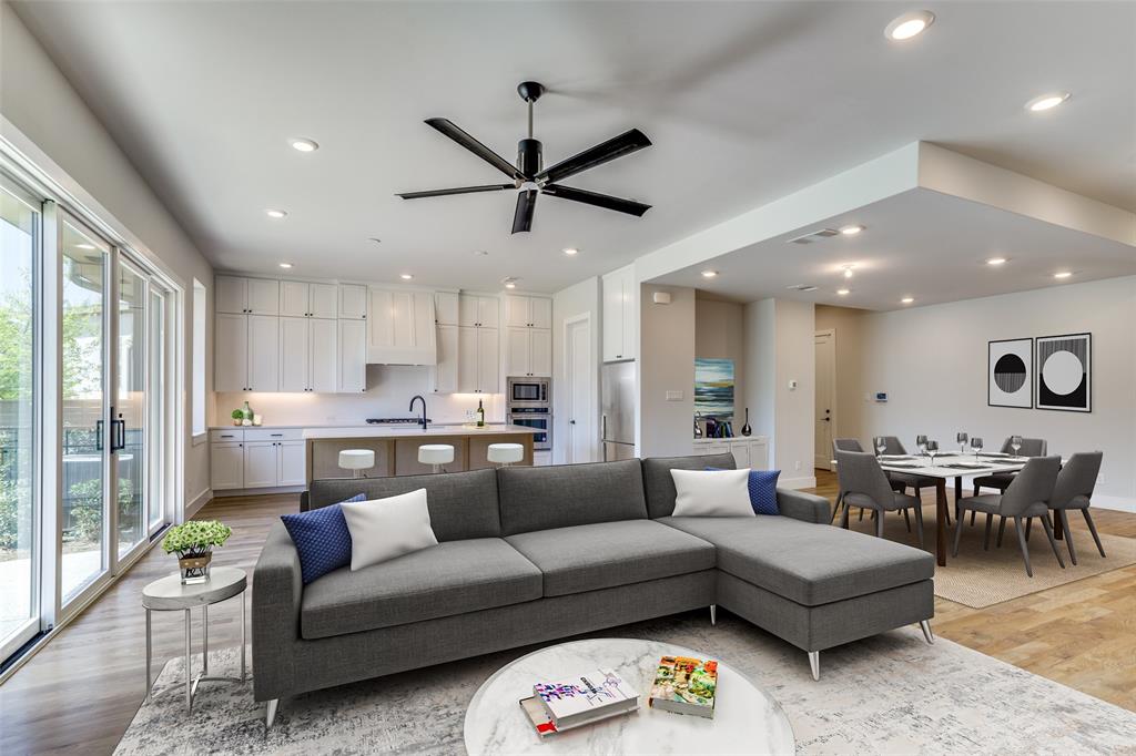 a living room with furniture kitchen view and a large window