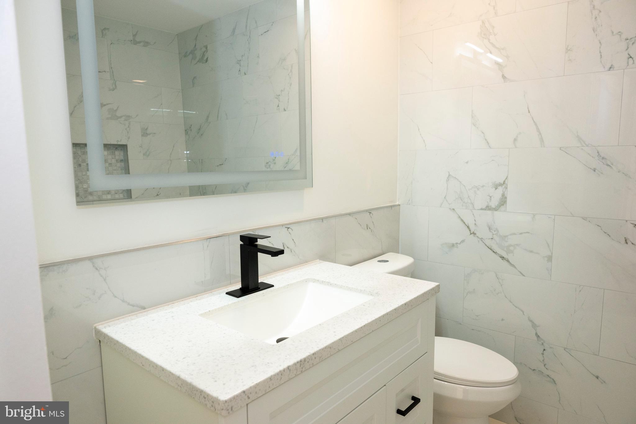 2201 Strahle Street, Unit D3 Philadelphia, PA 19152 - Photo 4 of 21 a bathroom with a sink a toilet and mirror