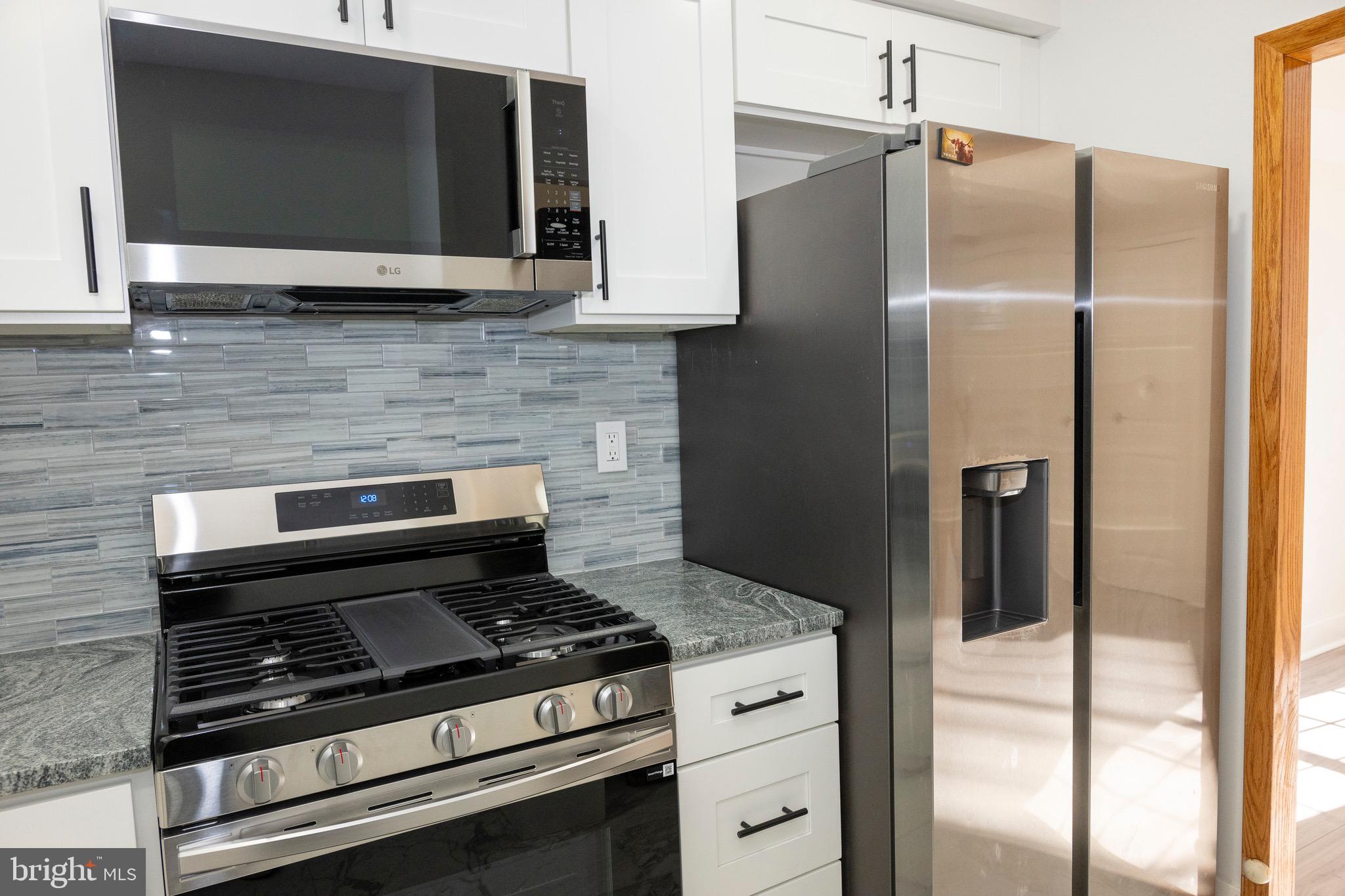 2201 Strahle Street, Unit D3 Philadelphia, PA 19152 - Photo 5 of 21 a kitchen with stainless steel appliances granite countertop a stove microwave and refrigerator