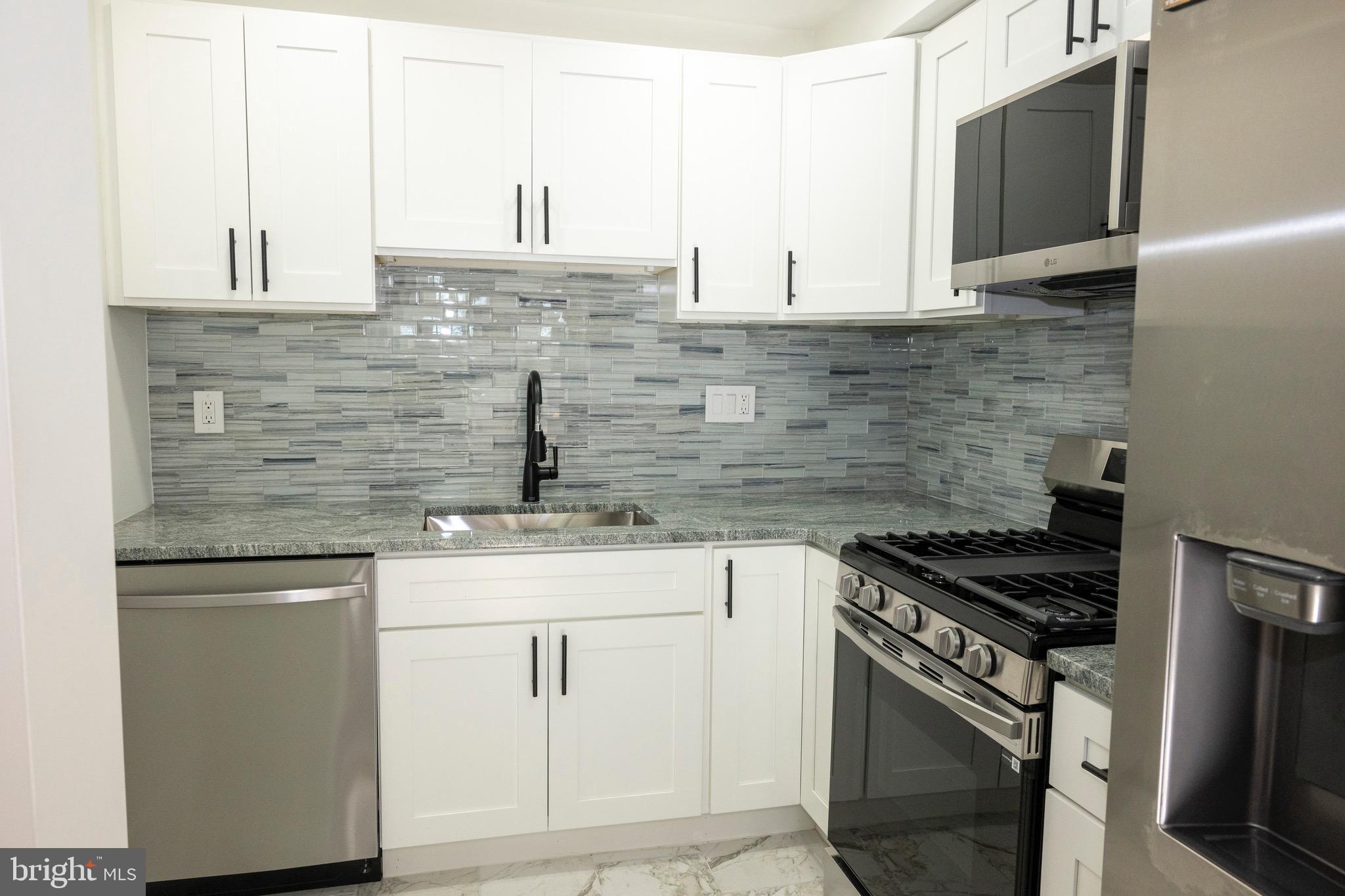 2201 Strahle Street, Unit D3 Philadelphia, PA 19152 - Photo 6 of 21 a kitchen with stainless steel appliances granite countertop a sink stove and cabinets