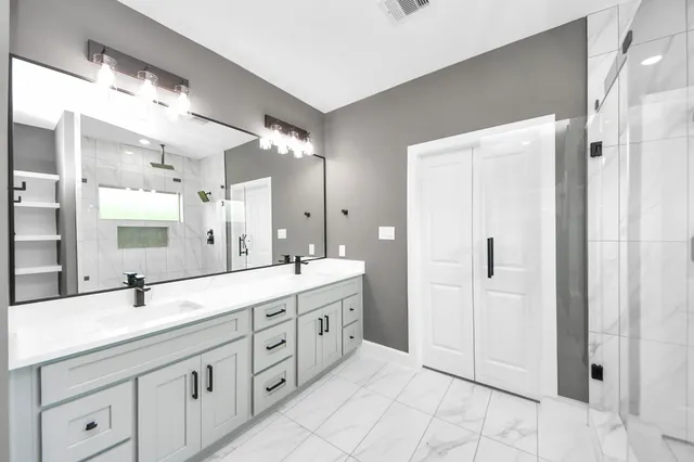 a bathroom with a double vanity sink mirror and double