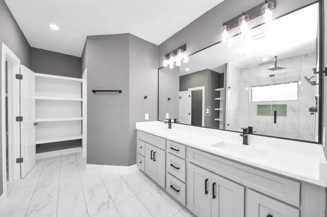 a bathroom with a double vanity sink a mirror and shower